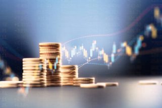 Coin stacks before blue financial graph. Horizontal composition with copy space. Business and finance concept.