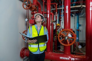 Engineer or technician work checking Fire suppression system and fire equipment. Engineer check red generator pump for water sprinkler piping and fire alarm control system