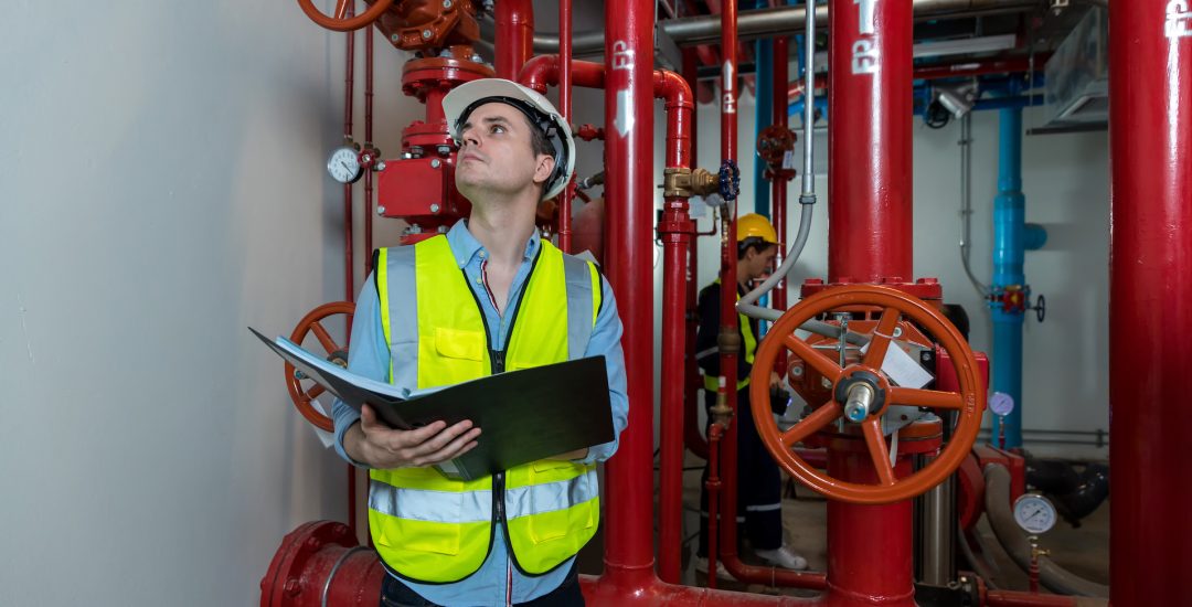 Engineer or technician work checking Fire suppression system and fire equipment. Engineer check red generator pump for water sprinkler piping and fire alarm control system