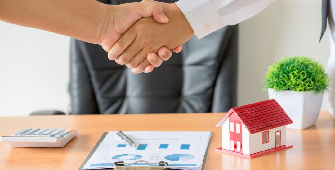 Side view hands of agent and client shaking hands after signed contract buy new apartment.