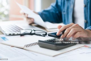 Investors are calculating profits and costs with calculators, growth and investment chart analysis, business planning and strategies to maximize sales profits. Long term business plan.