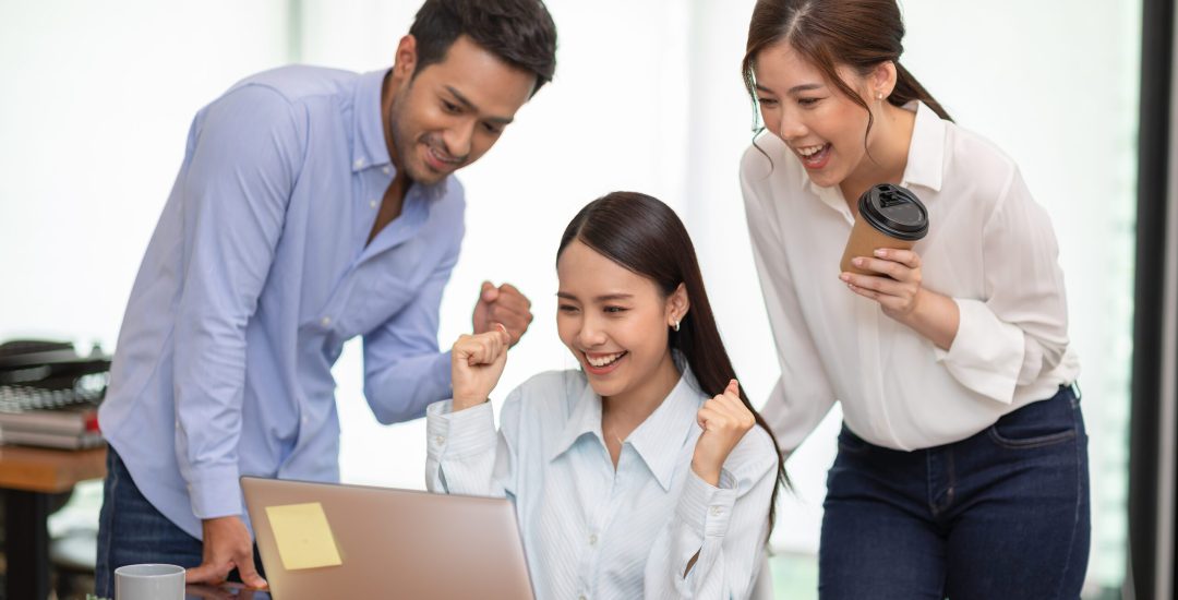 Group,Of,Young,Startup,Coworkers,Working,Together,Looking,At,Laptop