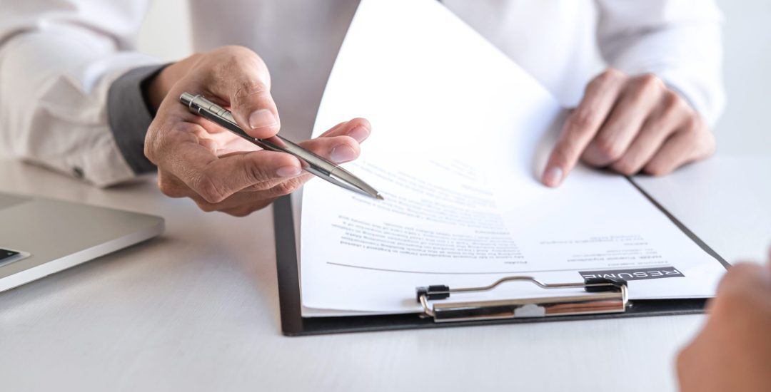 Employer or recruiter holding reading a resume during about colloquy his profile of candidate, employer in suit is conducting a job interview, manager resource employment and recruitment concept.