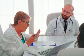 Medical experts having health seminar in hospital conference room, discussing about symptoms of patients. Clinic therapist talking with colleagues about disease for treatment development.