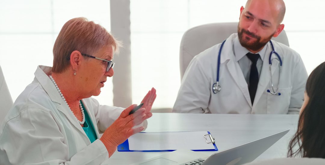 Medical experts having health seminar in hospital conference room, discussing about symptoms of patients. Clinic therapist talking with colleagues about disease for treatment development.