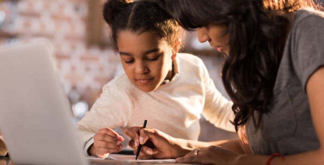 side view of mother helping daughter doing homework