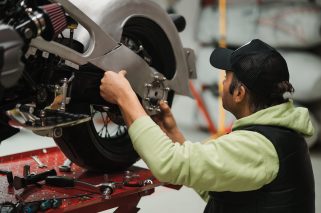Repairman repair motorcycle, maintenance in garage. Mechanic fixing bike in a modern shop