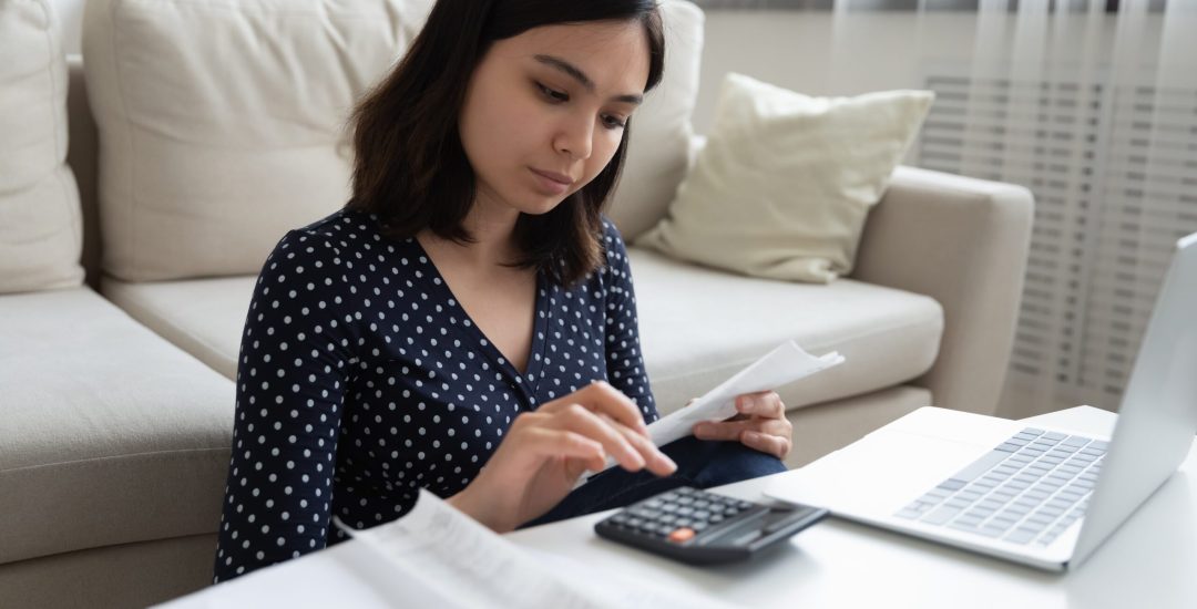 Concentrated,Millennial,Vietnamese,Female,Engaged,In,Home,Banking,Using,Calculator