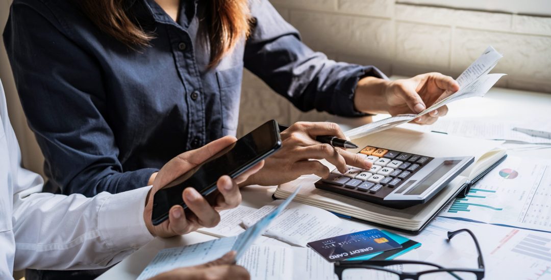 Stressed young couple checking bills, taxes, bank account balance and calculating expenses in the living room at home