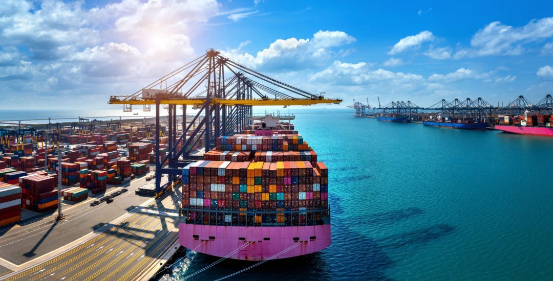 Aerial view of cargo ship and cargo container in harbor.