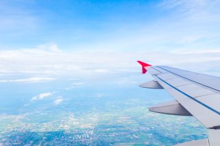 Wing of an airplane flying above the clouds