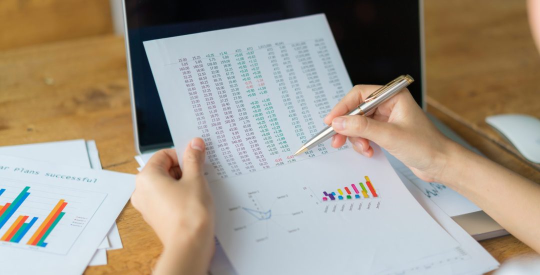 Business woman hand with Financial charts and laptop on the table