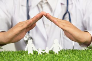 close up picture of doctor's hands posting symbol of home above family member model