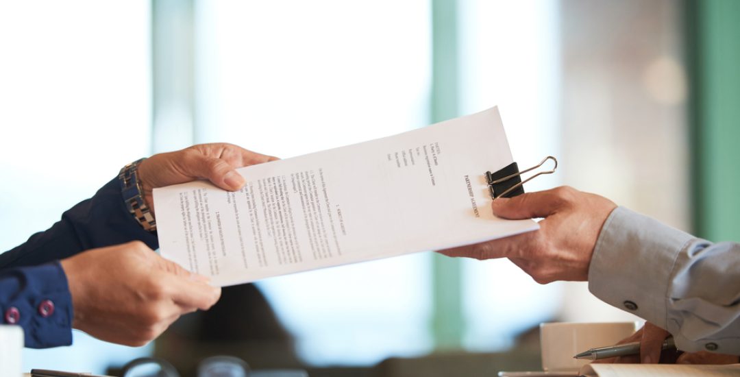 Business person giving partnership agreement to coworker