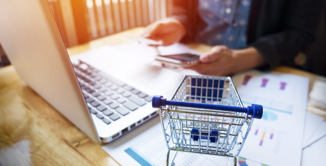 Cropped image of woman inputting card information and key on phone or laptop while shopping online.
