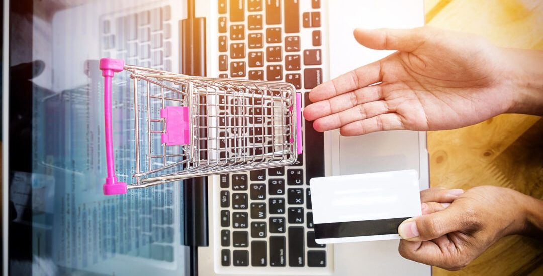 Cropped image of woman inputting card information and key on phone or laptop while shopping online.