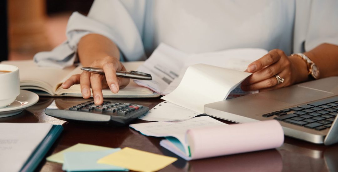 Hands of female entrepreneur working with bills and documents