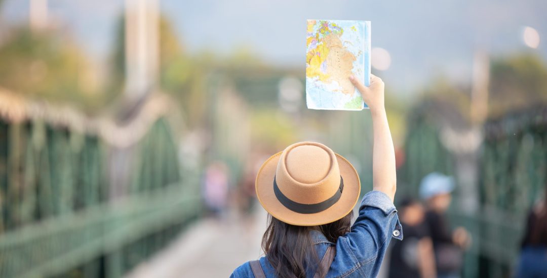 Female tourists on hand have a happy travel map.