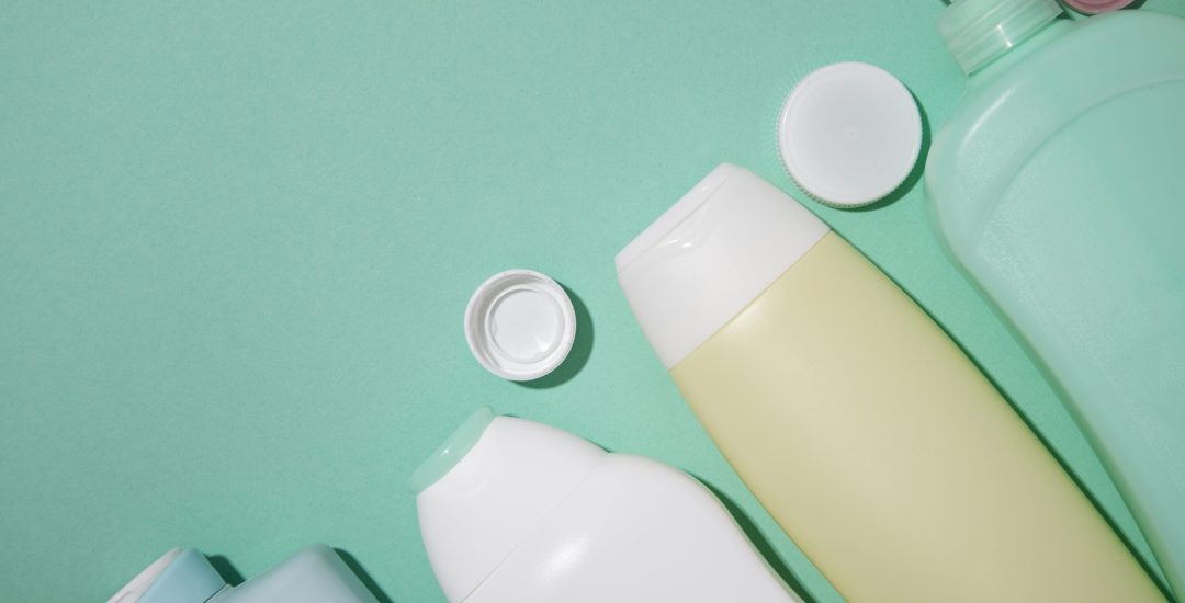 flat-lay-plastic-bottles-green-background