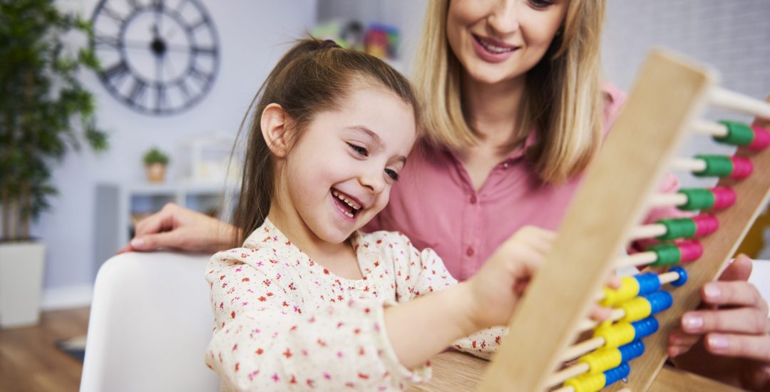 Girl and teacher using an abacus during homeschooling