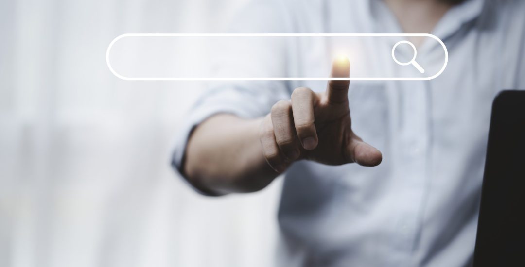 Hand touching with search icon for Search Engine Optimisation or SEO concept to find information by internet connection.