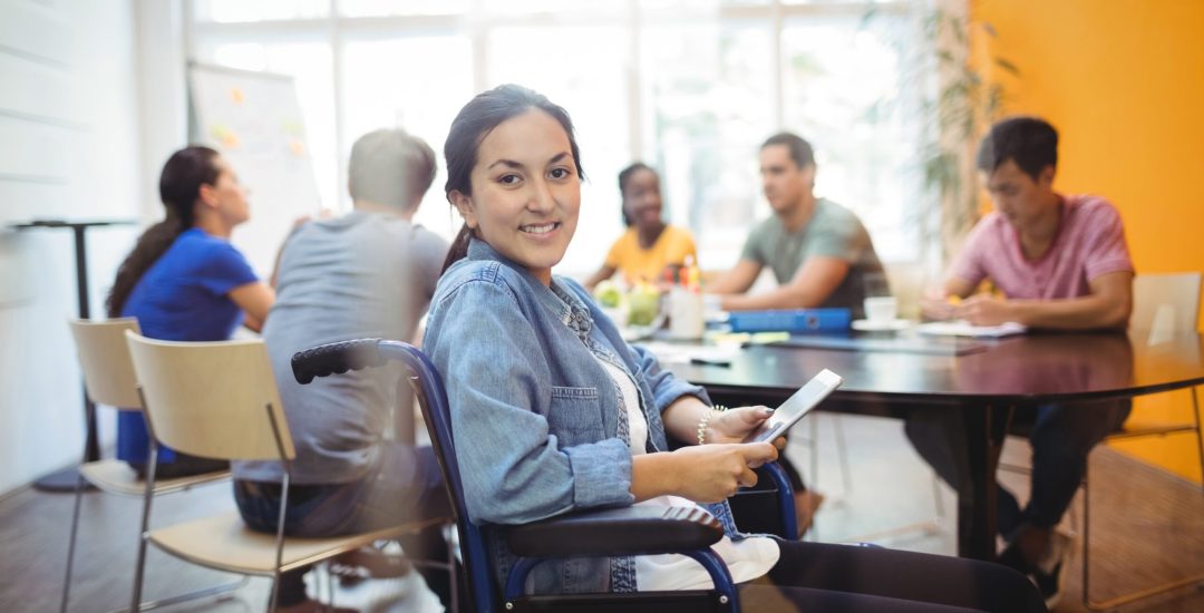 Portrait of handicapped business executive using digital tablet in office