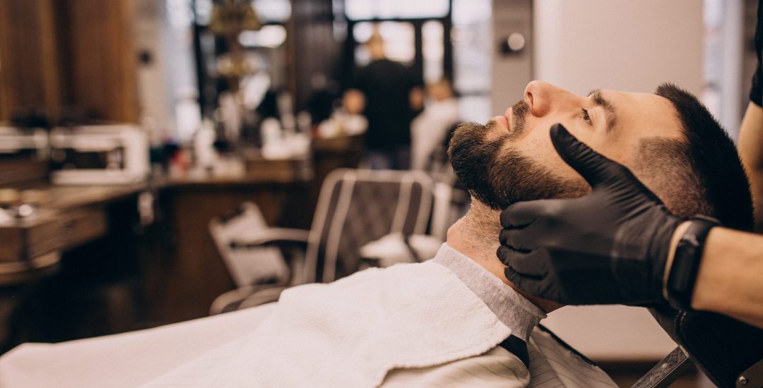 Man at a barbershop salon doing haircut and beard trim