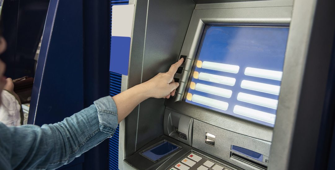 People waiting to get money from automated teller machine - people withdrawn money from ATM concept