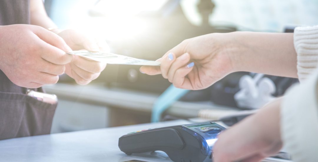 cash and card payment with chip and pin machine in shop.