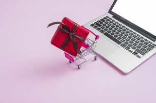 shopping-trolley-gift-near-modern-laptop