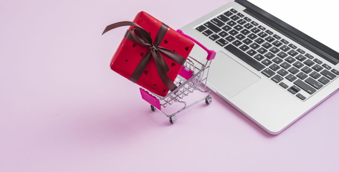 shopping-trolley-gift-near-modern-laptop