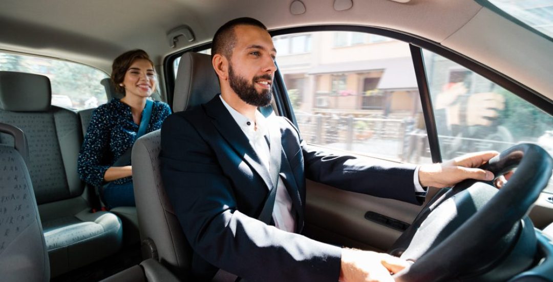 Similing,Taxi,Driver,Talking,With,Female,Passenger.