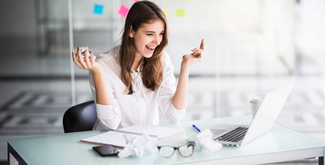 successful businesswoman working on laptop computer in her office dressed up in white strict clothes