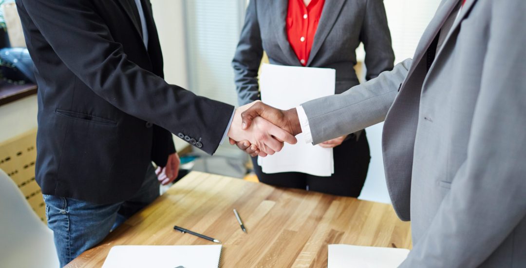 Successful business partners handshaking after signing contract
