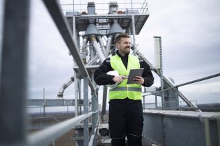 trabajador-de-una-fabrica-industrial-de-pie-sobre-la-construccion-de-alta-metal-de-la-planta-de-produccion