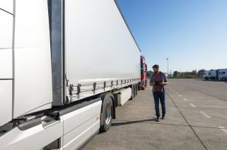 truck-driver-inspecting-vehicle-trailer-tires-before-driving