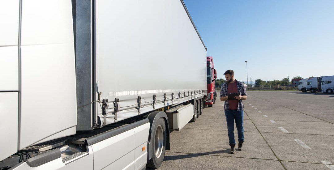 truck-driver-inspecting-vehicle-trailer-tires-before-driving