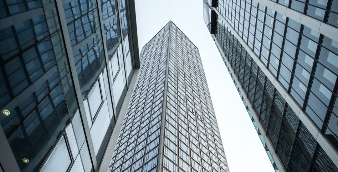 A vertical low angle shot of high rise skyscrapers in a glass facade in Frankfurt, Germany