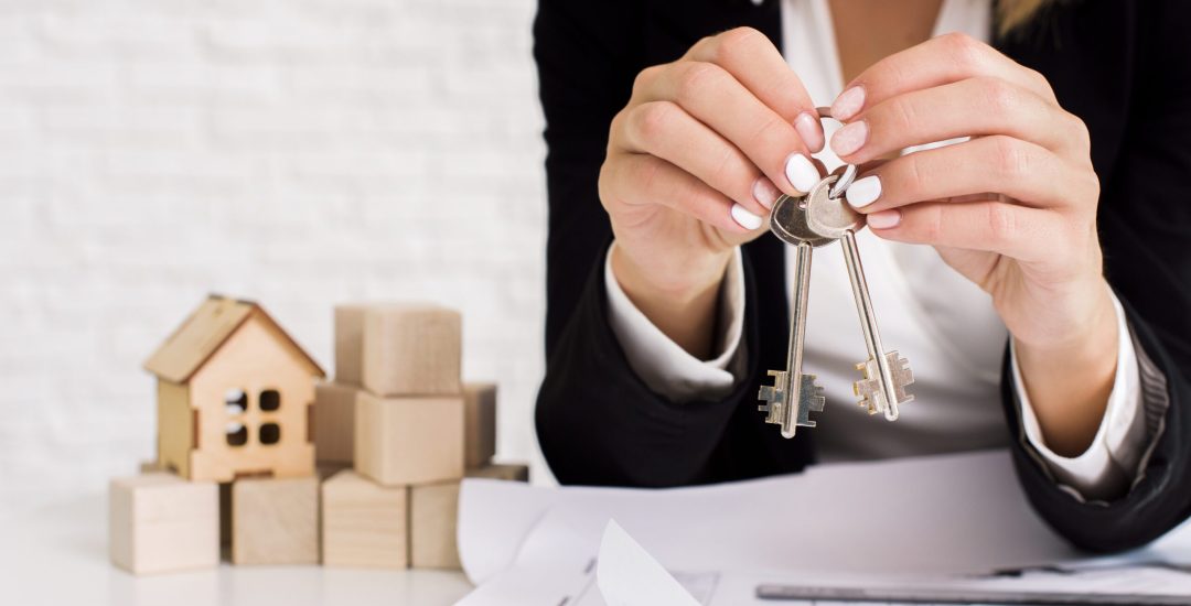 woman-holding-set-of-keys-with-wooden-cubes