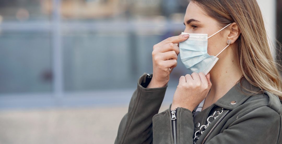 Woman in the city. Person in a mask. Coronavirus theme.