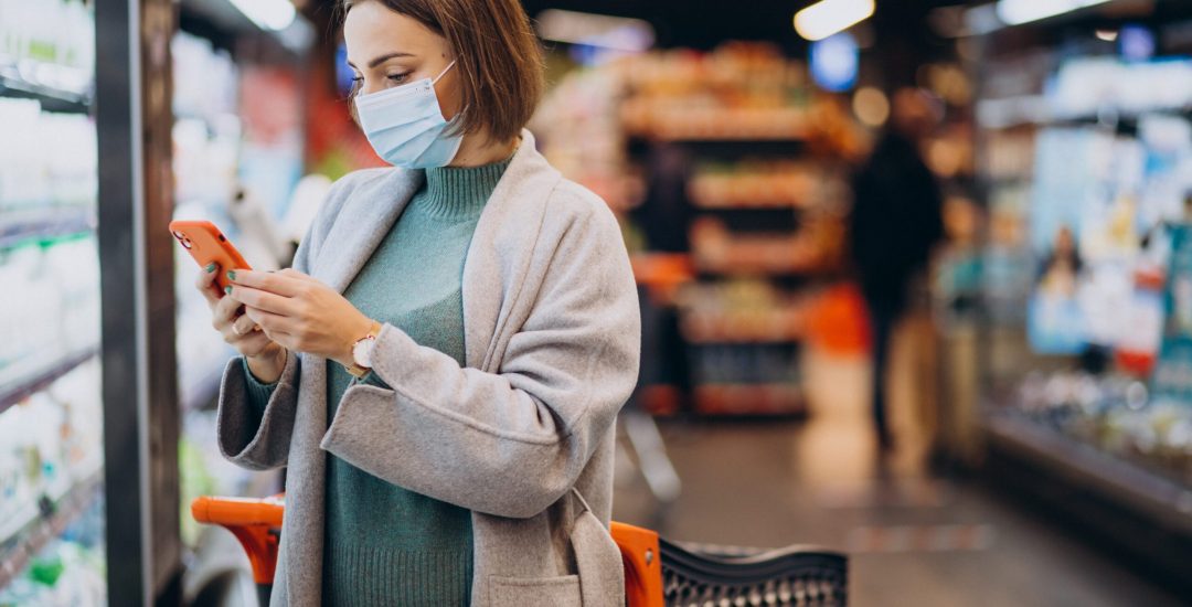 Woman wearing face mask and shopping in grocery store