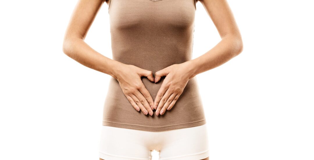 Slim Woman with hands on belly forming heart shape