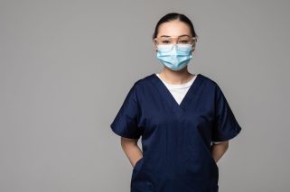Asian Chinese medicine doctor woman or hospital nurse in scrubs using protective medical face mask in prevention against virus infection